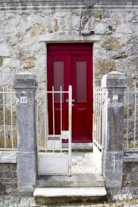 a red door on the side of a stone building at Guest House VC17 in Sintra
