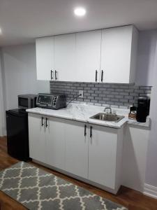 a kitchen with white cabinets and a sink at Luxurious 1BR - 1BA Apt Modern Bright with free parking in Brampton