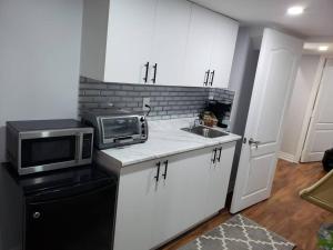 a small kitchen with a microwave and a sink at Luxurious 1BR - 1BA Apt Modern Bright with free parking in Brampton