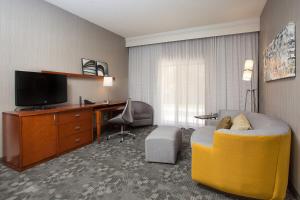 a hotel room with a yellow chair and a desk at Courtyard by Marriott Boston Westborough in Westborough