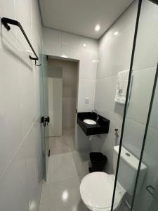 a white bathroom with a toilet and a sink at Honório Pousada-Caldas do Jorro BA in Tucano
