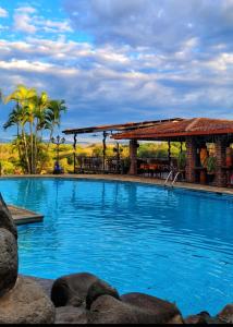 a large swimming pool with a gazebo and blue water at El Tejado in Suchitoto