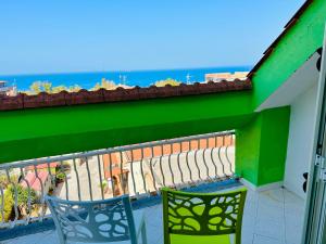 Tropea Family Rooms - B&B Il Cavallino في تروبيا: شرفة مع كرسيين وإطلالة على المحيط