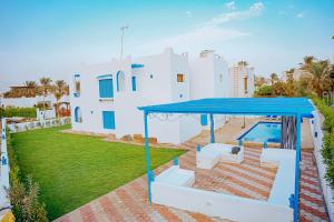 a house with a swimming pool and a blue roof at 4 bedrooms villa with private pool in Tunis village faiuym in Qaryat at Ta‘mīr as Siyāḩīyah