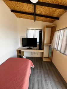 sypialnia z łóżkiem i biurkiem z telewizorem w obiekcie CASA MARIN Majagua w mieście Oaxaca