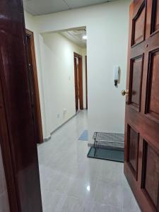 una stanza vuota con una porta e un corridoio di Oasis Hostel a Abu Dhabi