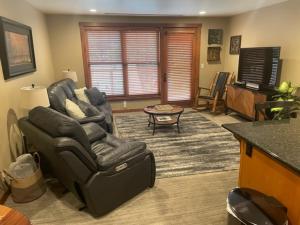 a living room with a couch and a chair and a table at Penthouse Mountain Haven with Community Spa Room in Kellogg