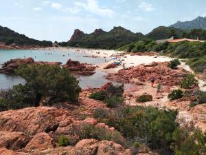 a group of people on a beach near the water at Tempesta Home in Lanusei