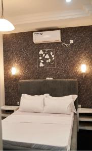 a bedroom with a bed with a air conditioner on the wall at appartement cosy free bonapriso in Douala