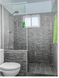 La salle de bains est pourvue d'une douche, de toilettes et d'une fenêtre. dans l'établissement Vila na Mágica Baía da Murdeira, à Beirona