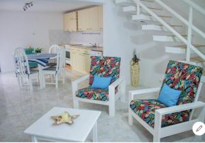 a living room with chairs and a table and a staircase at Vila na Mágica Baía da Murdeira in Beirona