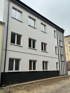 a white building with windows on the side of it at Closer Place in Tomaszów Mazowiecki