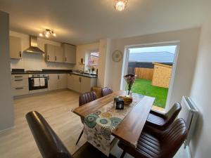uma cozinha e sala de jantar com mesa e cadeiras em New Comfy Family Friendly home in Canterbury em Sturry