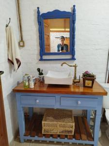um homem tirando uma foto de um lavatório azul em uma casa de banho em Sitio com jaccuzi, fogão a lenha em Vitória da Conquista