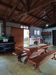 einen Picknicktisch in einem Zimmer mit Klavier in der Unterkunft Sitio com jaccuzi, fogão a lenha in Vitória da Conquista