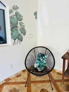 a black chair in a room with a painting of palm trees at Casa Karma in Puerto Escondido