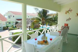 uma varanda com uma mesa e 2 copos de vinho em Lagoon Ocean Resort 2 bdrm/2bath with beach access em Lagun