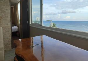 a room with a table and a view of the ocean at Apartamentos Commodore Bay Club in San Andrés