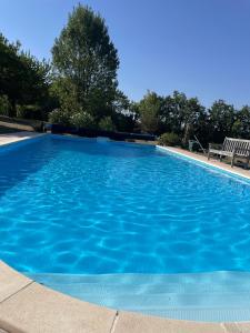 a large swimming pool with blue water at charme de l'ancien au coeur de la vallée sud charentaise in Bardenac