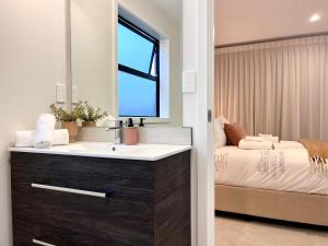 baño con lavabo y cama en Luxury Villa, Central, Golf and Cafés - By KOSH BNB en Hamilton