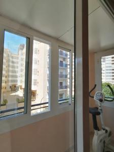 a room with three windows and a vacuum at ROOMS Beach 5 MIN Playa in Alicante