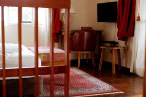 a bedroom with a bed and a desk and a television at Golden Hill Parker Hotel in Elmina