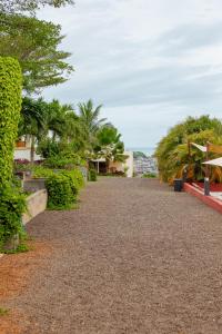 a gravel road with trees and houses in the distance at Golden Hill Parker Hotel in Elmina