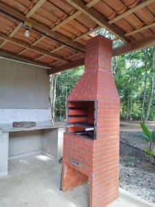 um forno de tijolo sentado sob um telhado de madeira em Sitio com jaccuzi, fogão a lenha em Vitória da Conquista