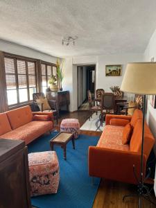 a living room with orange couches and a blue rug at Casa Santa María 2 con jardín y barbacoa in Arévalo