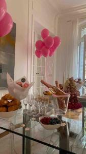 a glass table with pink balloons and wine glasses at Splendid Eiffel Tower & La Seine - 8 Beds in Paris