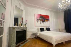 um quarto branco com uma cama e uma lareira em Splendid Eiffel Tower & La Seine - 8 Beds em Paris