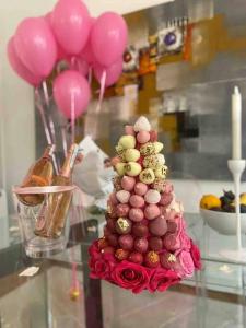 a cake with pink balloons on top of a table at Splendid Eiffel Tower & La Seine - 8 Beds in Paris
