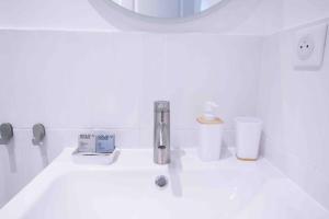 een wastafel in de badkamer met een kraan en een spiegel bij Joli Appartement in Choisy-le-Roi
