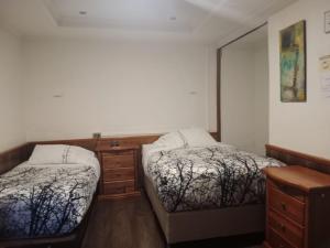 a bedroom with two beds and a dresser and a mirror at Hotel Terrasol Iquique in Iquique