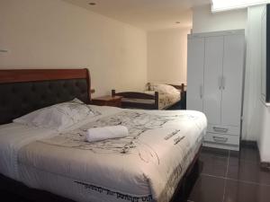 Un dormitorio con una cama con una toalla blanca. en Hotel Terrasol Iquique en Iquique