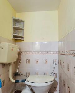 a bathroom with a white toilet in a room at Citylight Family Homestay in Mysore