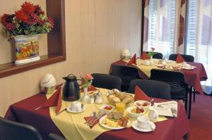 eine Reihe von Tischen in einem Restaurant mit Essen darauf in der Unterkunft Hotel An der Philharmonie in Köln