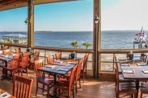 a restaurant with tables and chairs and a view of the ocean at Cozy Coastal Home Near Beaches, Shops, Restaurants in Southport
