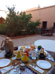 een tafel met borden en keukengerei bij La perle de saghro in Nkob