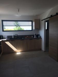 a kitchen with a large window above the counter at nature in Gardanne