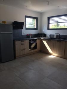 a kitchen with wooden cabinets and a refrigerator at nature in Gardanne