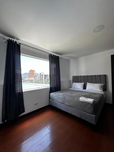 ein Schlafzimmer mit einem Bett und einem großen Fenster in der Unterkunft Hotel The MIRROR in Bogotá