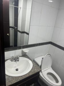 y baño con lavabo y aseo. en Hotel The MIRROR, en Bogotá