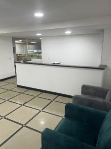 uma sala de espera com duas cadeiras e uma parede branca em Hotel The MIRROR em Bogotá