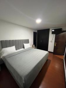 ein Schlafzimmer mit einem großen Bett in einem Zimmer in der Unterkunft Hotel The MIRROR in Bogotá
