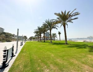 ein Park mit Palmen am Strand in der Unterkunft Paradis De La Mer Al Zeina 507A1 in Abu Dhabi