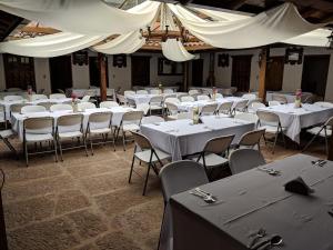 a room filled with tables and chairs with white tables and ceilings at POSADA AQUILINO in Cucunubá