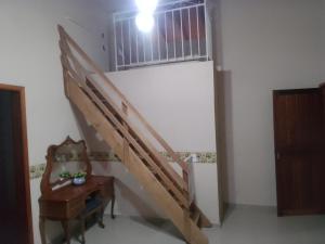 - un escalier en bois dans une chambre avec une table et une fenêtre dans l'établissement Recanto das pedras, à São Thomé das Letras