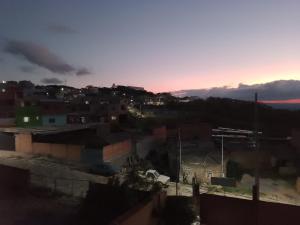 - une vue sur une ville avec le coucher du soleil en arrière-plan dans l'établissement Recanto das pedras, à São Thomé das Letras