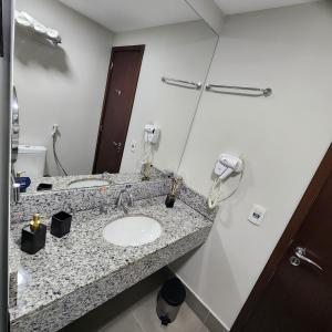 uma casa de banho com um lavatório e um espelho em Suíte Premiere no Rio de Janeiro